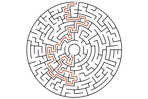 Circular maze in black and white with curved paths and a highlighted orange solution line.